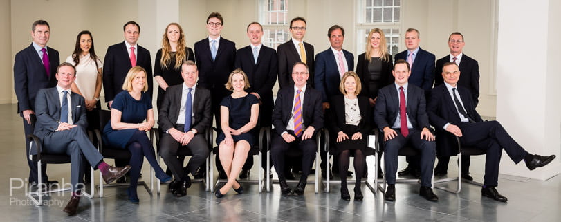 Company photograph of team in London offices sitting and standing