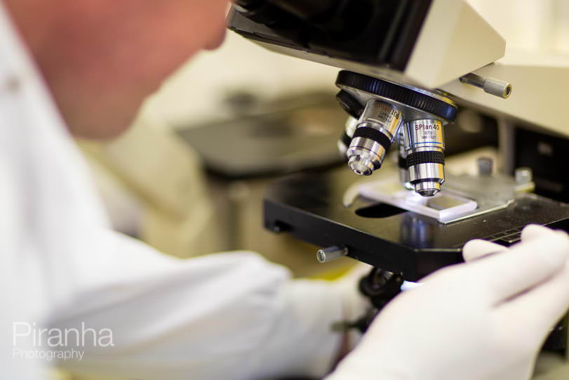 photography of medical research assistant using micoroscope