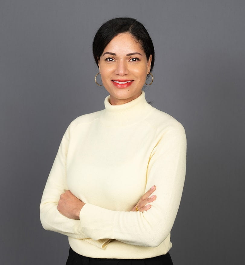 Corporate headshot photograph of woman in office with greybackground.