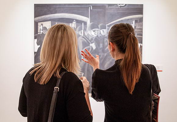 Corporate guests admiring art at London gallery