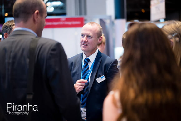 Attendees chatting at stand at energy event