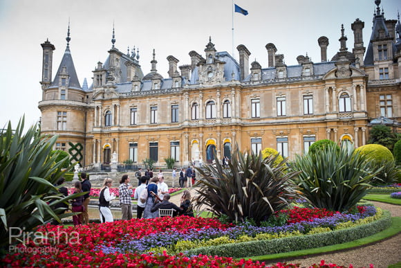 Photograph of exterior or Waddeson Manor with guests outside