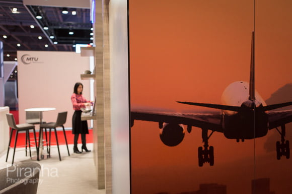 Photography of imagery and woman working at Excel exhibition stand