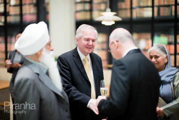 Evening Event Photography at the British Library in London 8 Guests meeting one another during evening event photographed by Piranha