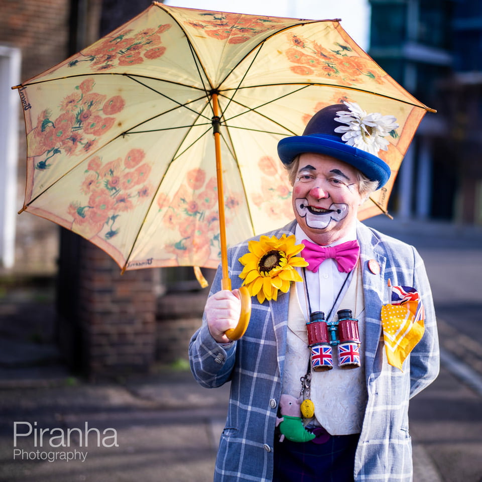 Photograph of clown with umbrella at Grimaldi Service, Haggerston in London