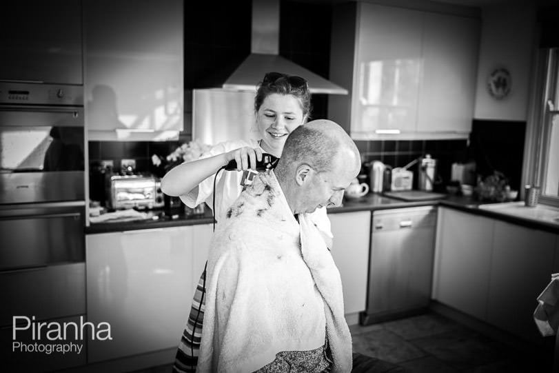 Clementine cutting Douglas's hair in the kitchen with clippers during lockdown.