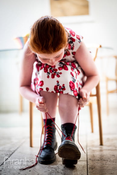 Putting new red laces into Dr Marten boots ready for a walk