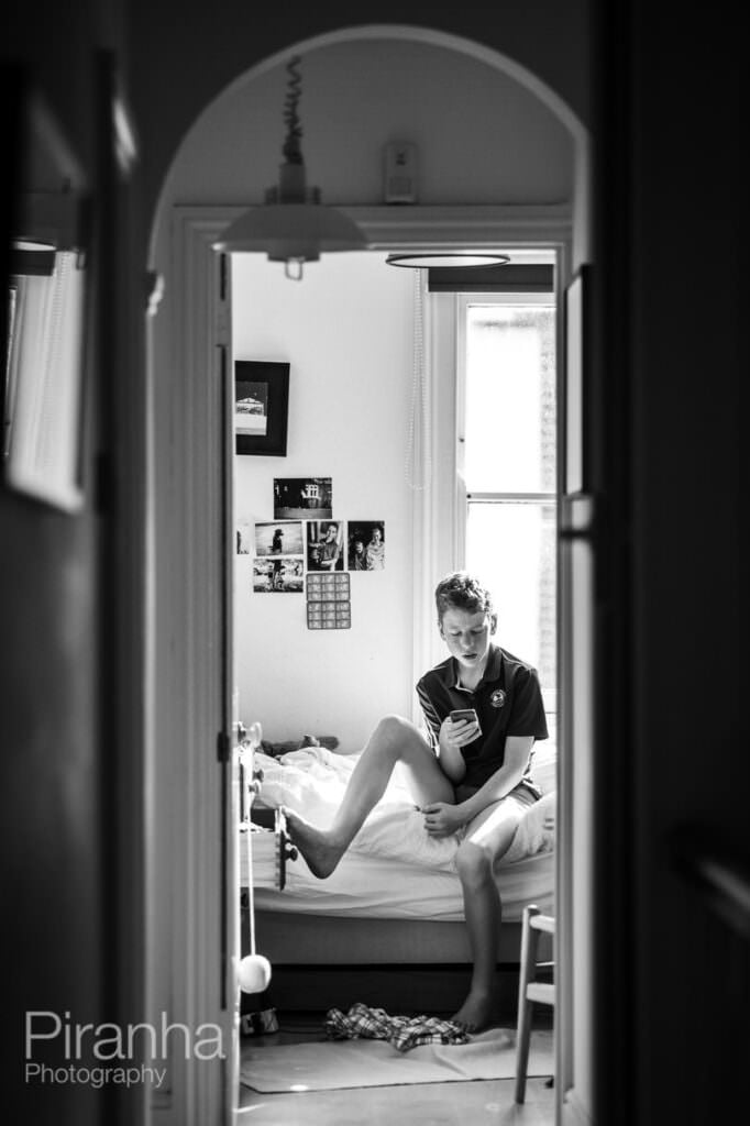 Boy looking at phone during lockdown in bedroom