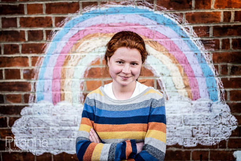 Teenager photographed in front of NHS rainbow drawing on house wall in Oxford