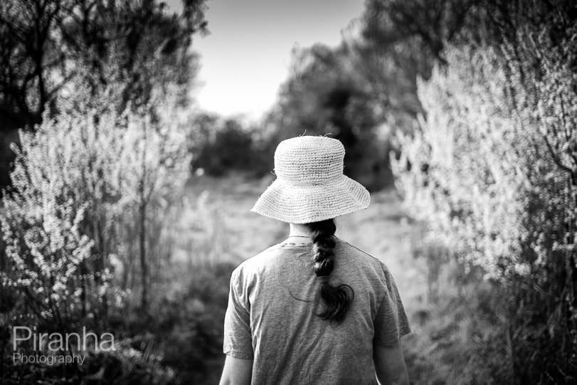 Photography project picture of teenager wearing a hat walking through the spring blossom