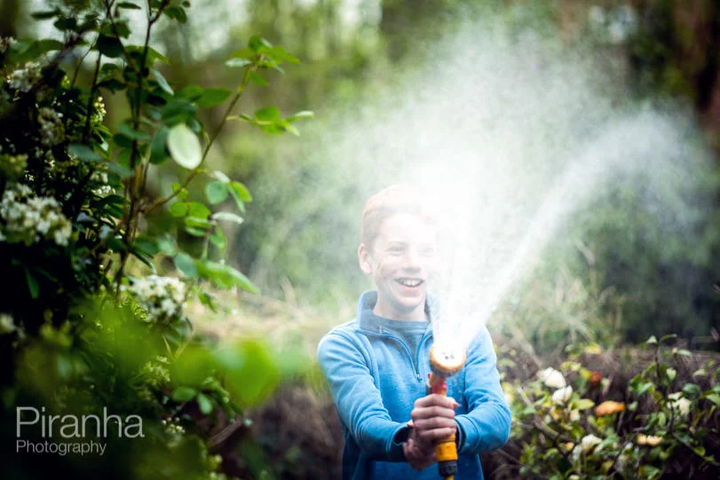 Teenager watering the garden during lockdown.