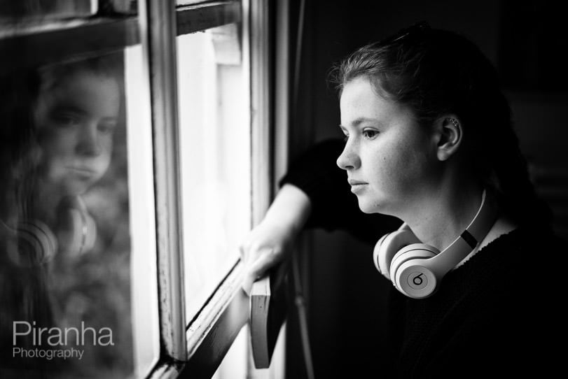 Teenage girl looking out of window during Covid19 Lockdown