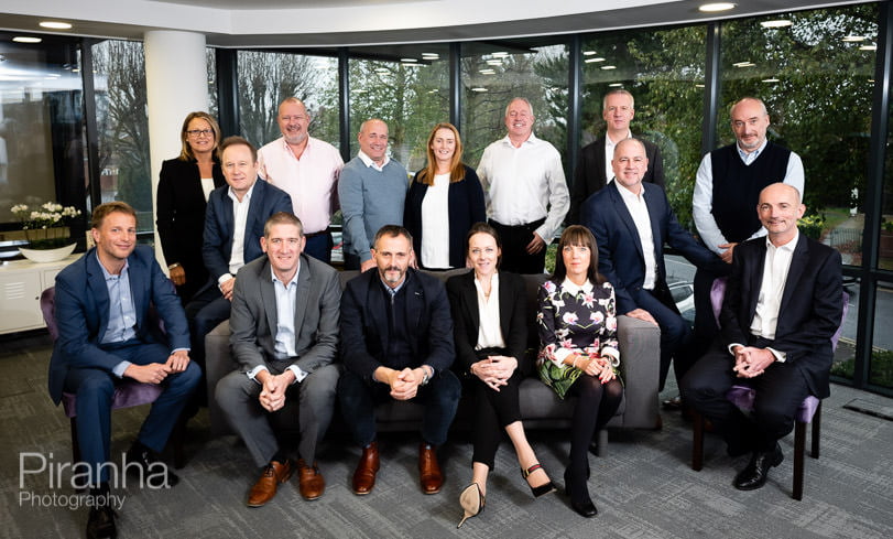 Management team photographed together in company headquarters