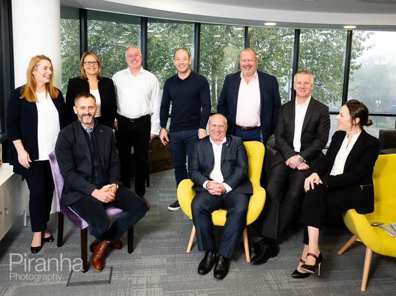 Management team photographed together in company headquarters