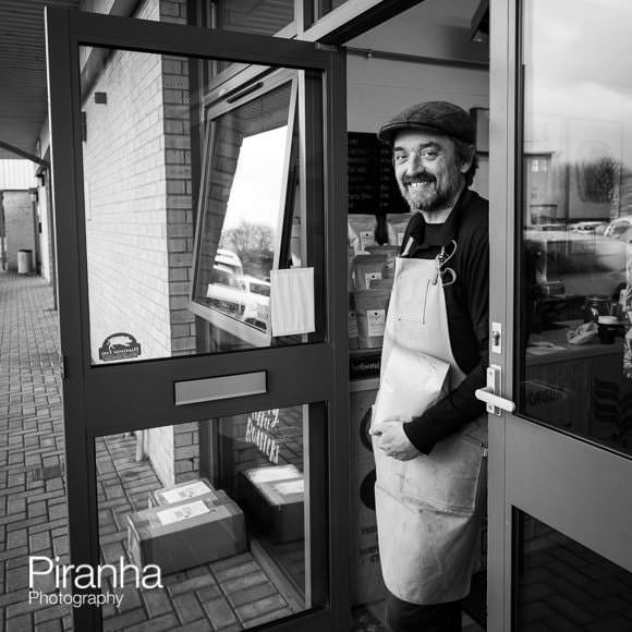 Photograph of shop owner at entrace to coffee shop