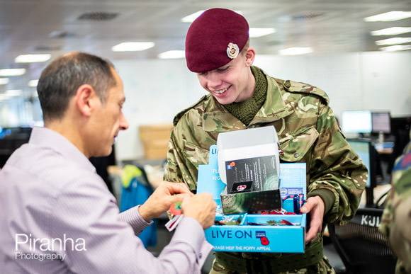 Service man selling poppy to office worker in London