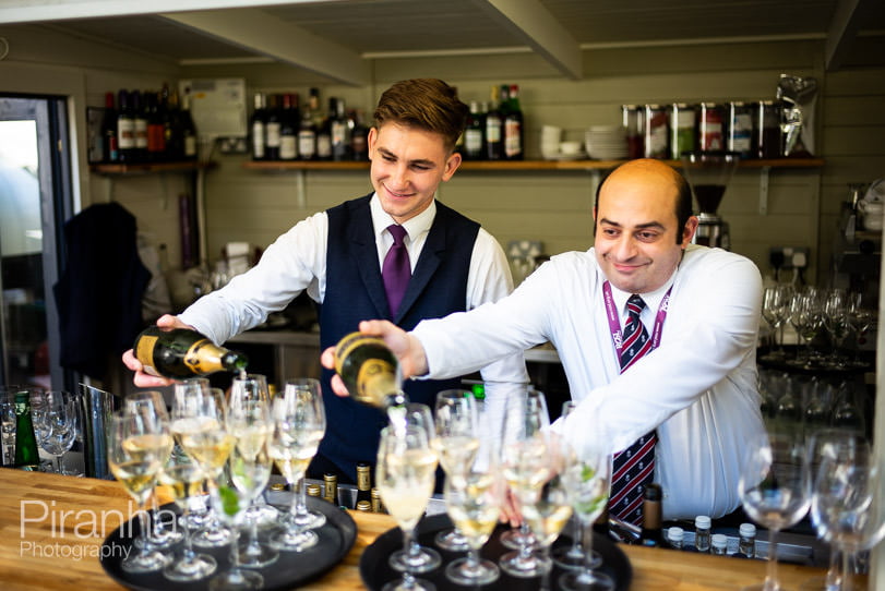 Waiters preparing drinks at bar in London venue