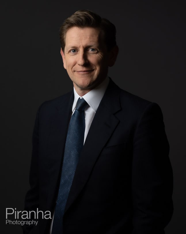 Headshot photography against grey backdrop.