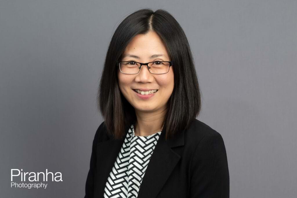 Headshot photograph taken against grey backdrop by Piranha Photography - not AI generated.