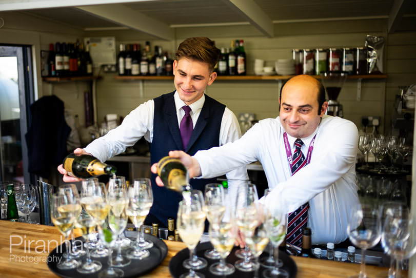 Waiters preparing drinks at bar in London venue by London event photographer