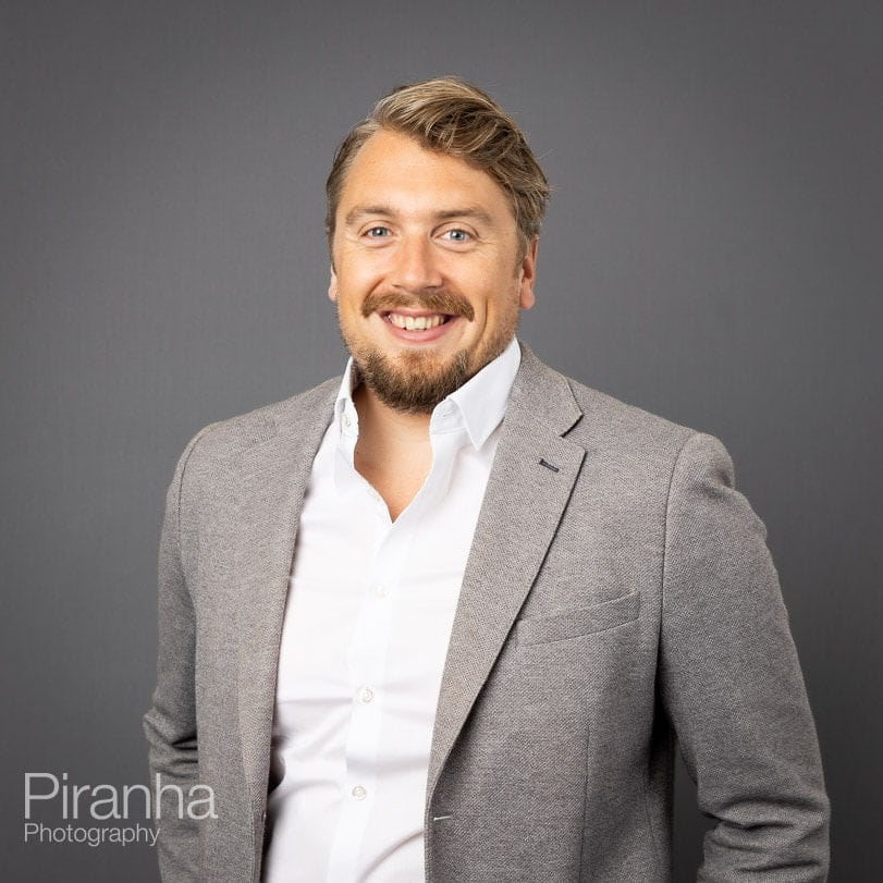 Corporate portrait photograph taken with grey background.
